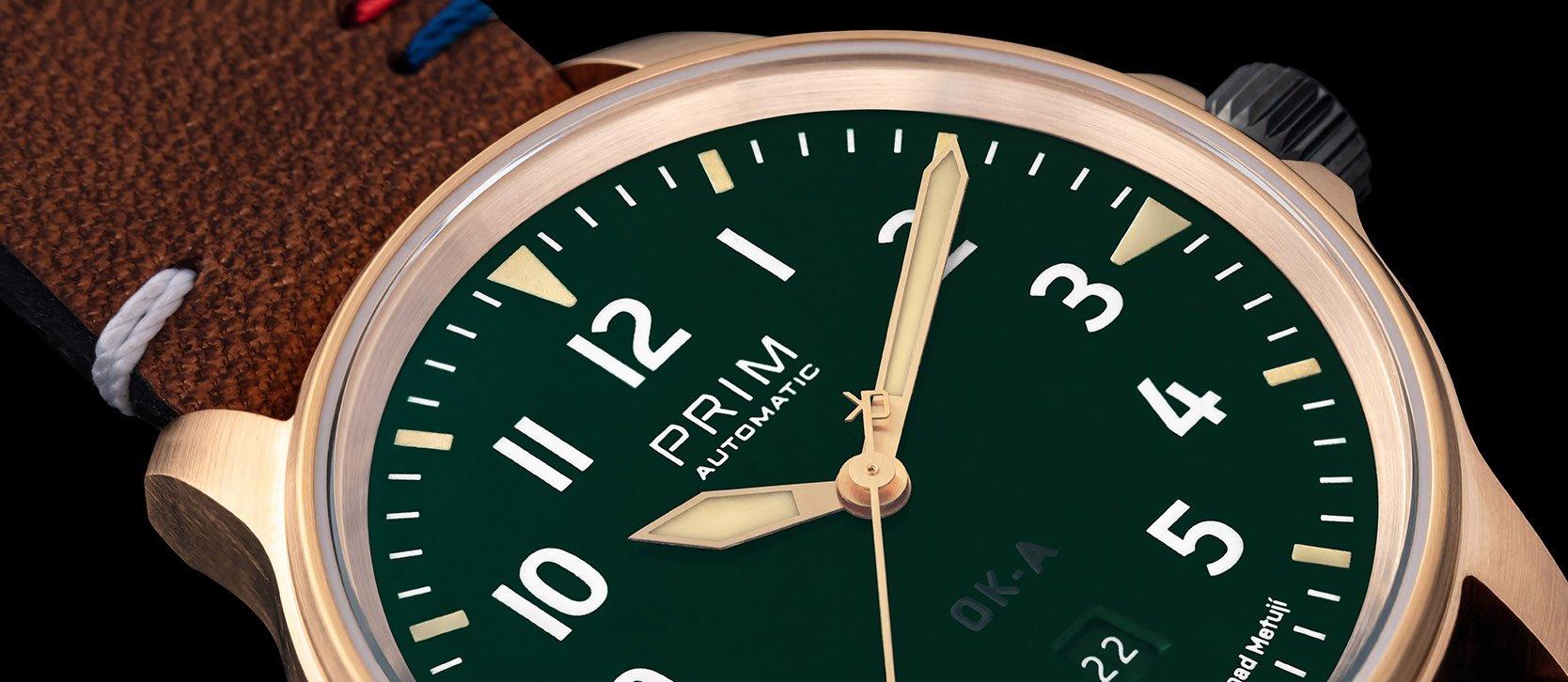 Vteřinovou ručku hodinek PRIM OK-A v bronzu zdobí označení československých letadel OK